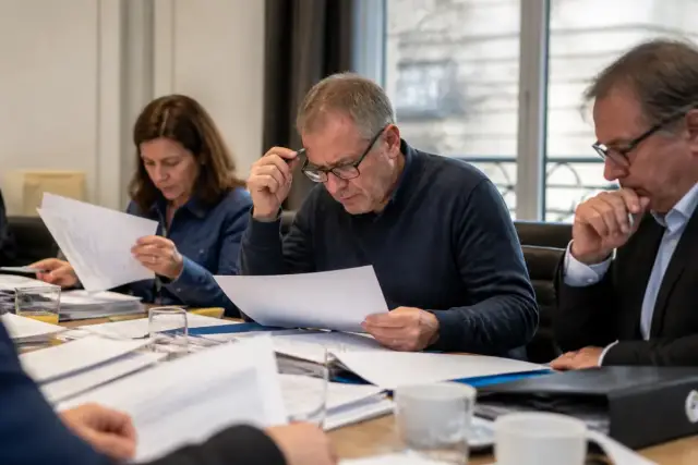 Réunion d'équipe analysant des documents financiers avant un redressement judiciaire adapté à l'entreprise